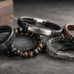 Men’s bracelet collection featuring black leather, brown leather, silver chain, and natural stone bead bracelets displayed on a dark stone surface.